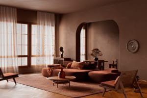 Salon chaleureux et moderne avec des tons marron et des rideaux voilés.