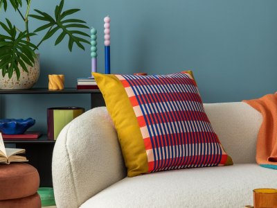 Interior desgin of modern living room interior with colorful decorations and accessories, plants, sofa, coffee table, lamp and plant. Blue wall. Home decor. Template
