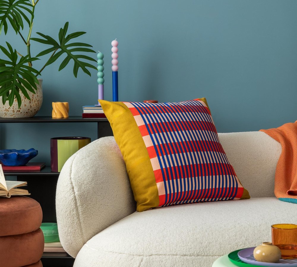 Interior desgin of modern living room interior with colorful decorations and accessories, plants, sofa, coffee table, lamp and plant. Blue wall. Home decor. Template