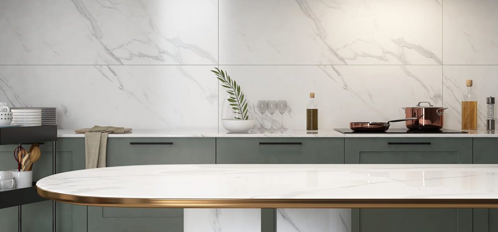 Cuisine moderne avec plan de travail en marbre blanc, casseroles en cuivre, crédence marbrée et meubles vert foncé